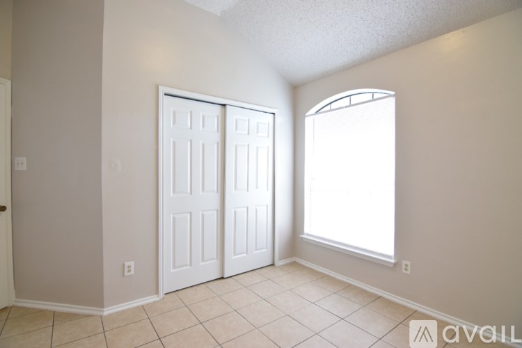 A room with a white door and a window.