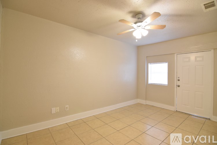 A room with a ceiling fan and a door.