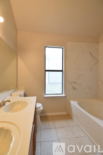 A bathroom with a tub, toilet, and sink.