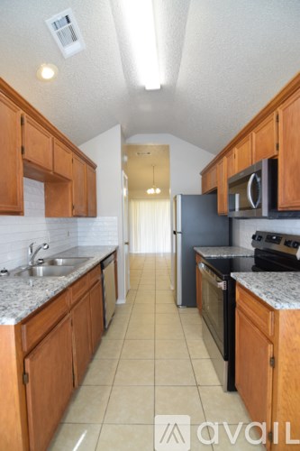 A kitchen with wooden cabinets and a black refrigerator.