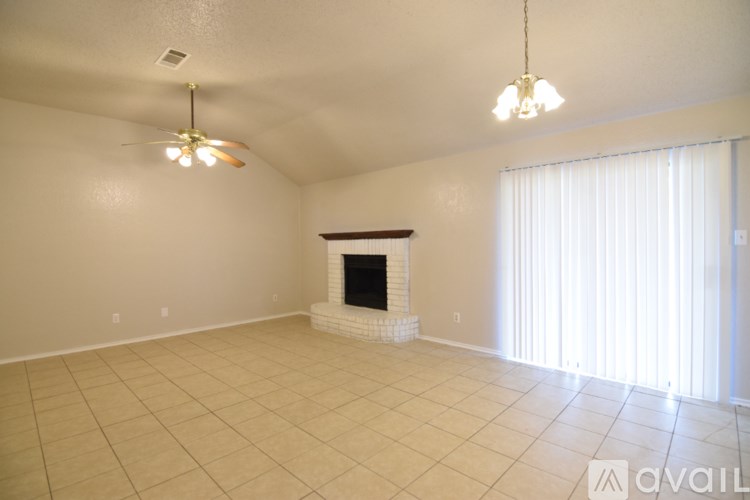 A living room with a fireplace and a ceiling fan.