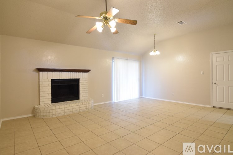 A spacious living room with a fireplace and a ceiling fan.