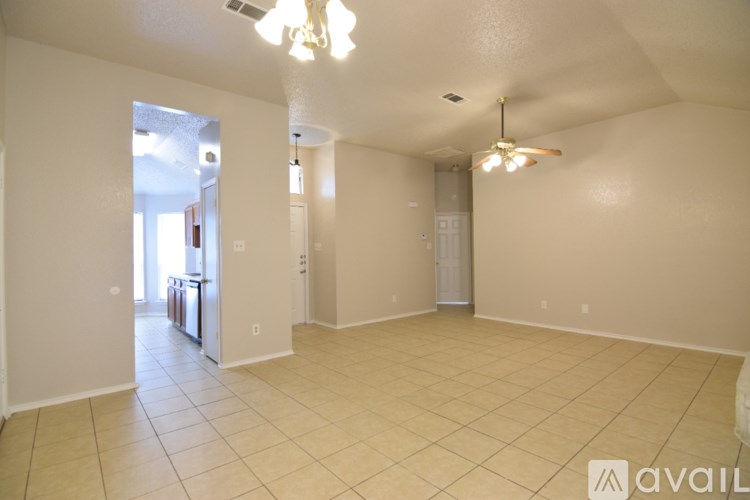 A spacious room with tiled flooring and a ceiling fan.