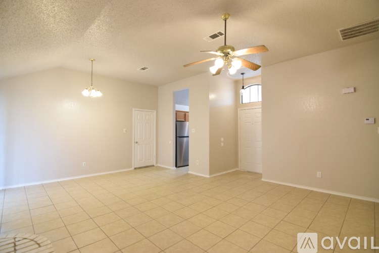 A spacious room with a ceiling fan and tiled flooring.