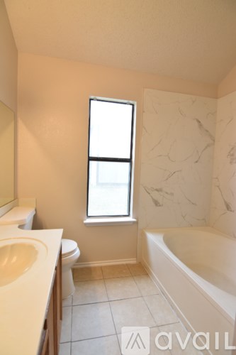 A bathroom with a tub, toilet and sink.