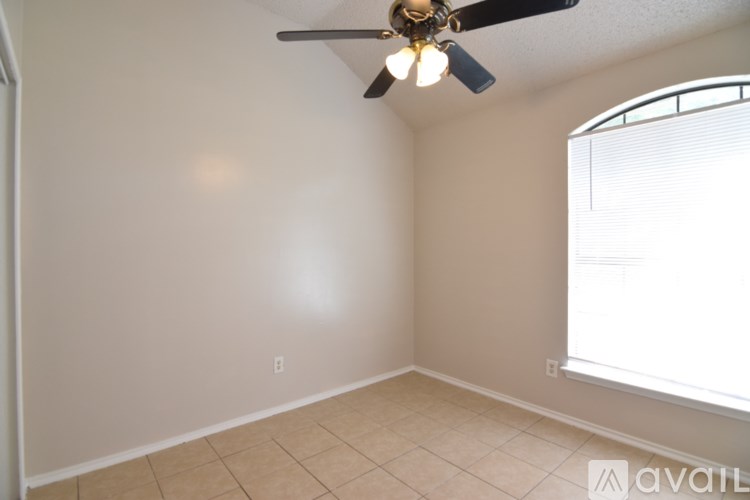 A room with a ceiling fan and a window.