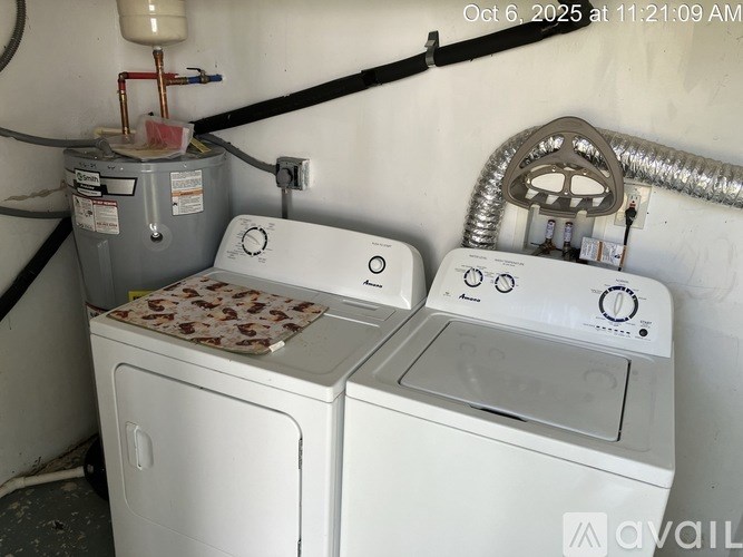 A pair of white front loading washing machines in a laundry room.