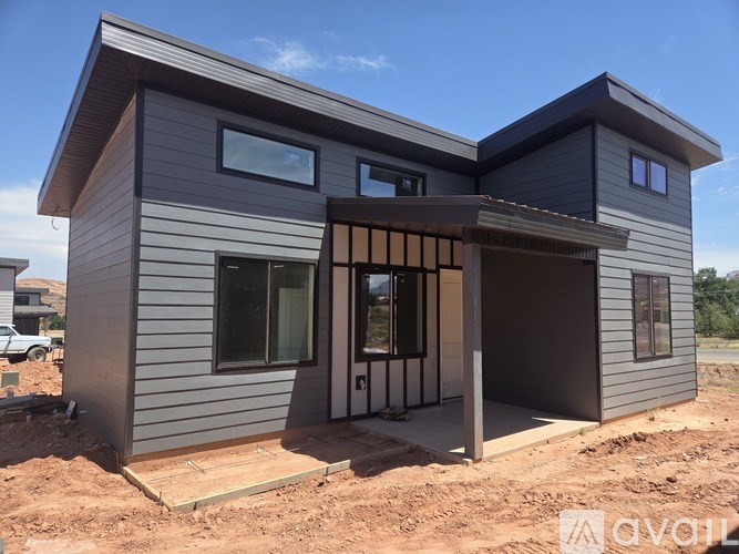 A modern house under construction with a grey exterior and a large entrance area.