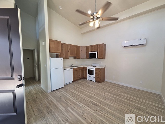 A kitchen with white appliances and wooden cabinets.