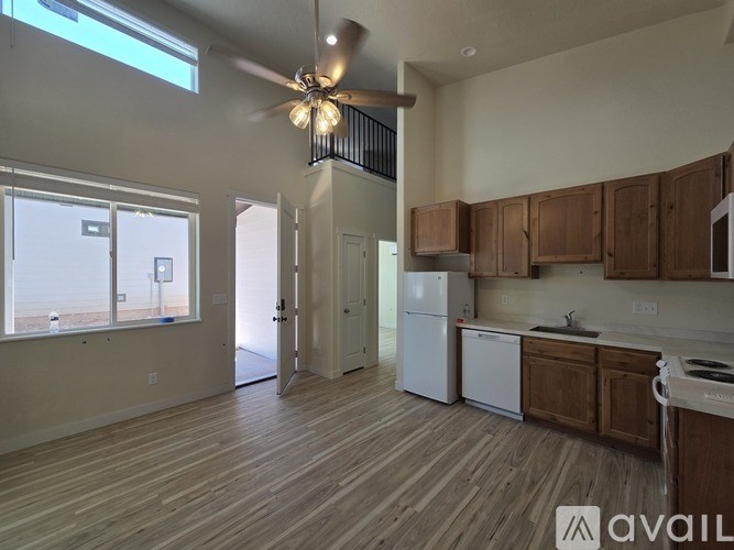 A kitchen with wooden floors and a white fridge.