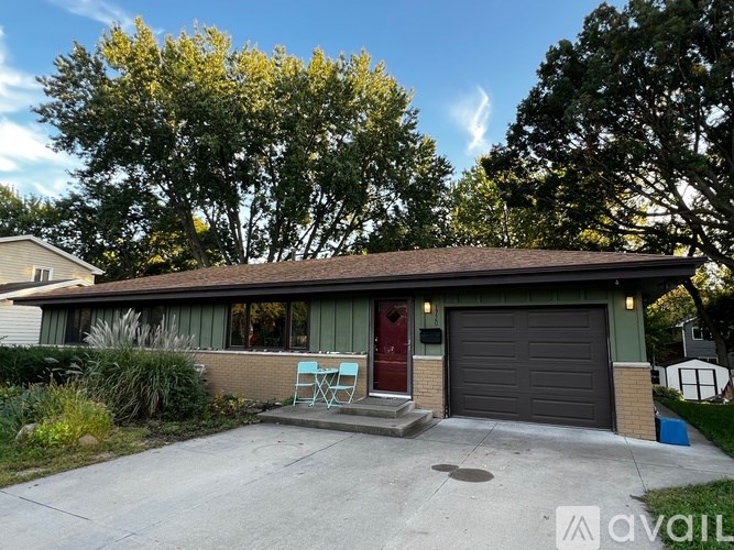 A house with a red door and a grey garage door.
