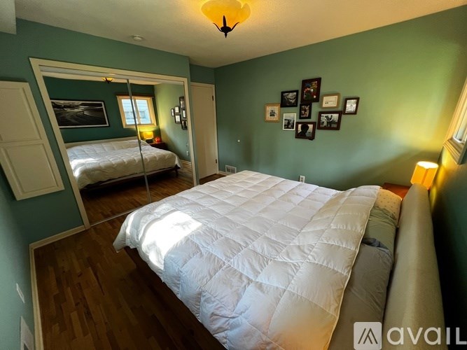 A bedroom with a large bed and a painting on the wall.