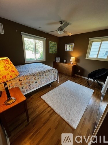 A bedroom with a bed, a chair, and a lamp.