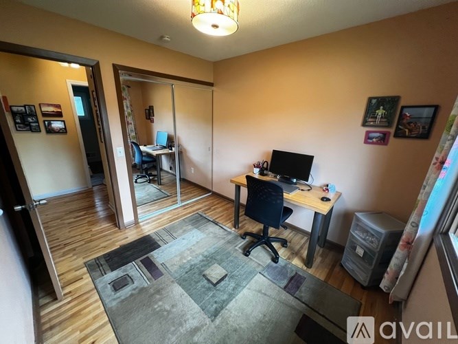 A room with a desk, chair, and computer setup.