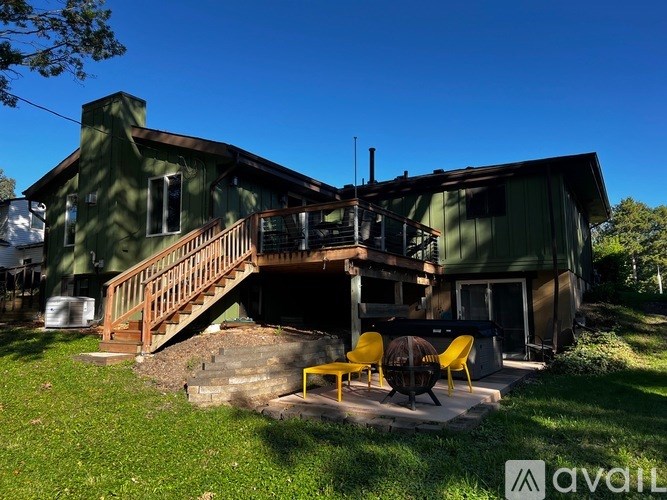 A house with a green exterior and a wooden deck.