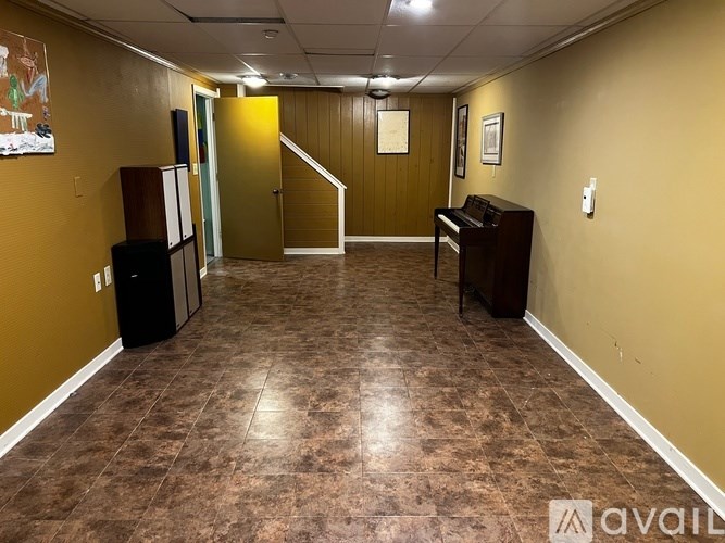A room with a brown floor and a yellow wall.