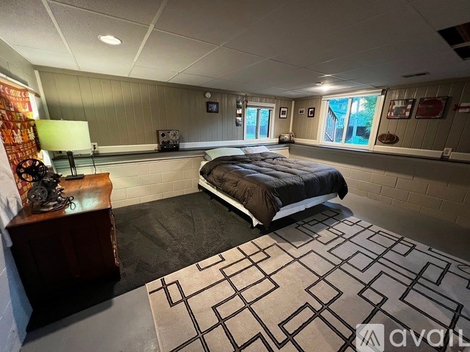 A bedroom with a large bed and a wooden nightstand.