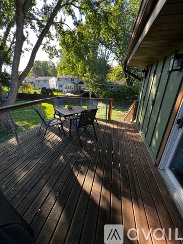A wooden deck with a table and chairs is shown.