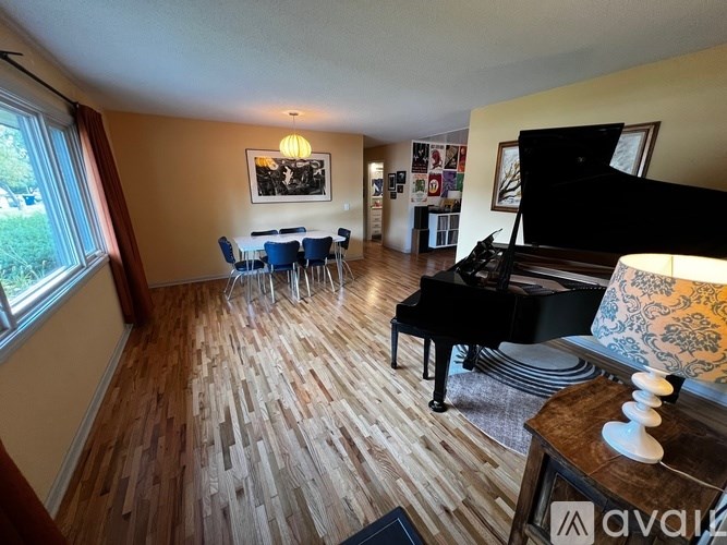 A living room with a piano and a dining table.