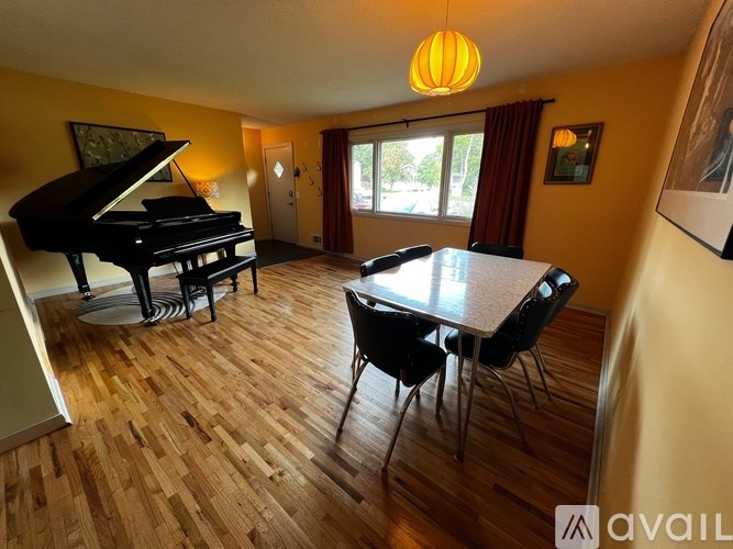 A room with a piano and a dining table.