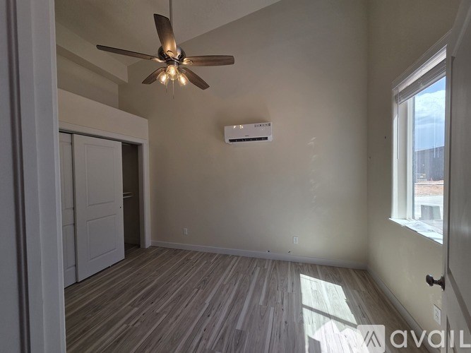 A room with a ceiling fan and a window.