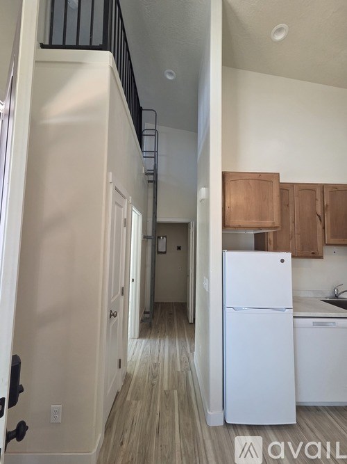A white refrigerator in a kitchen with wooden cabinets.
