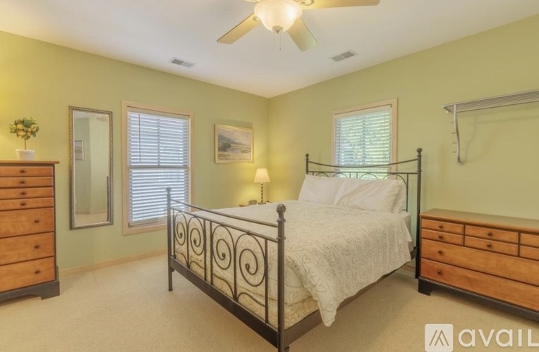 A bedroom with a bed, dresser, and mirror.