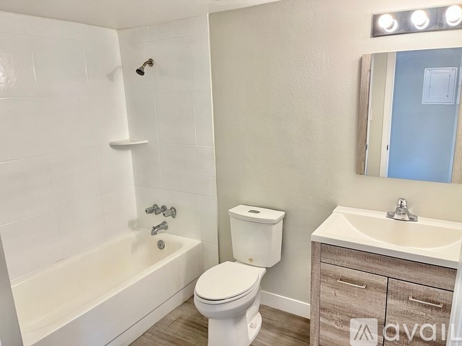 A white toilet sits next to a bathtub in a bathroom.