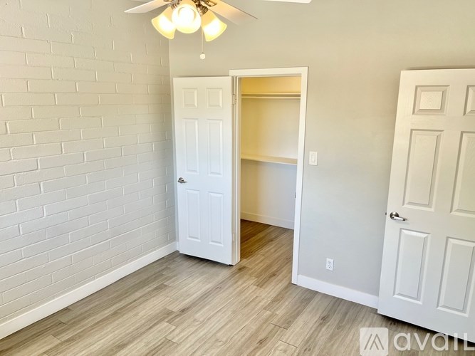 A room with a white door and a ceiling fan.