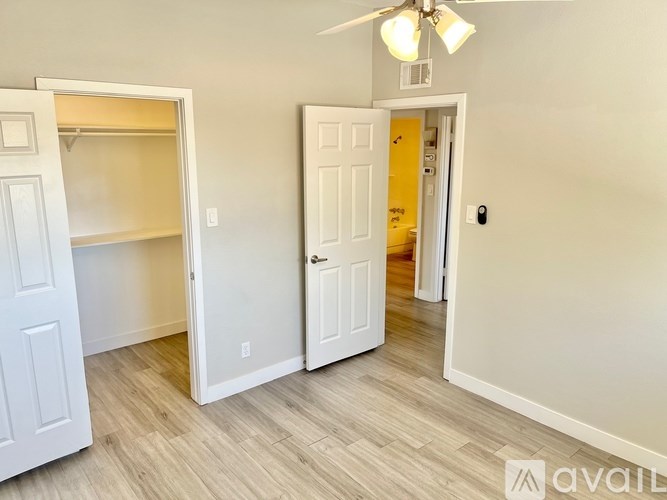 A room with a white door and a ceiling fan.