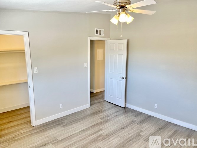 A room with a ceiling fan and two doors.