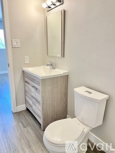 A white toilet sits next to a sink in a bathroom.