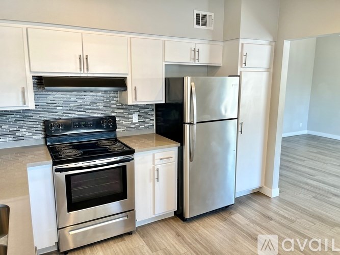 A modern kitchen with a stove, oven, and refrigerator.