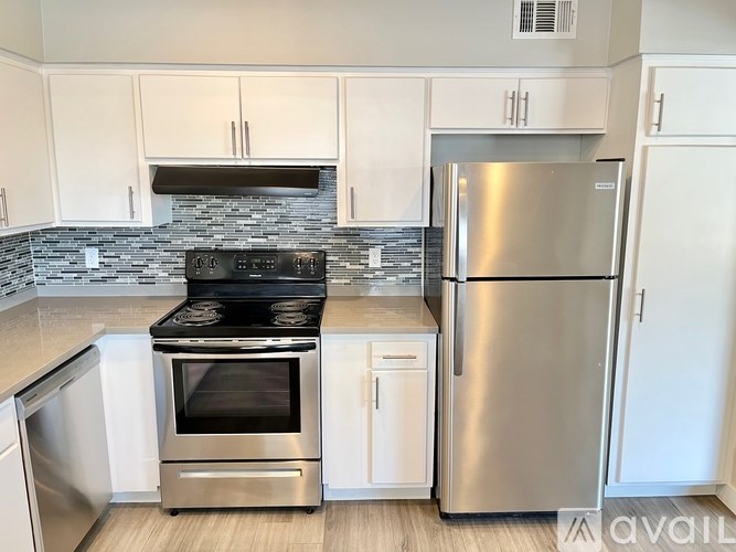 A modern kitchen with a stainless steel refrigerator and oven.