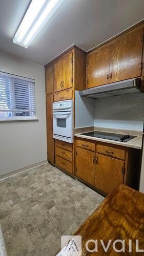 A kitchen with wooden cabinets and a tiled floor.