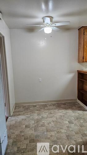 A room with a ceiling fan and a tiled floor.