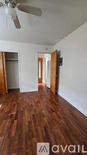 A room with wooden floors and a ceiling fan.