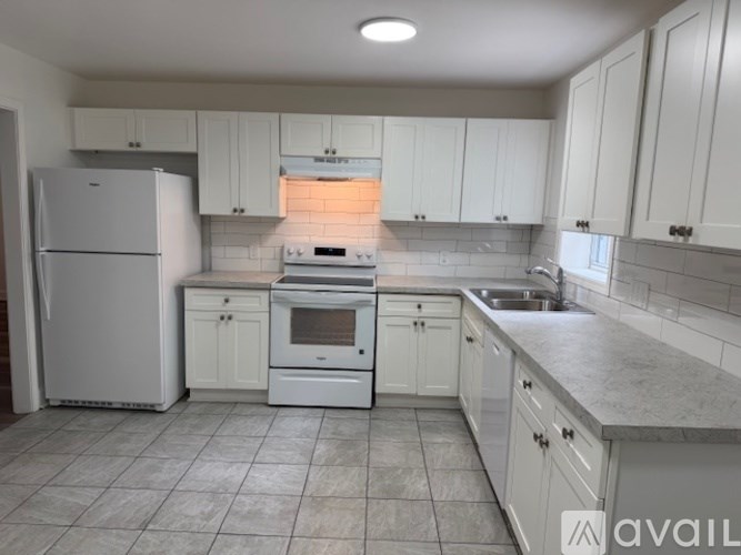 A kitchen with white appliances and cabinets.