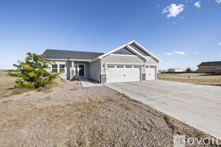 A house with a grey roof and a garage door is shown.