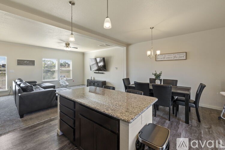 A kitchen area with a counter and chairs.