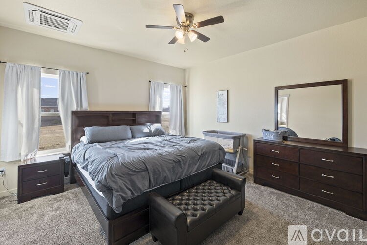A bedroom with a bed, dresser, and mirror.