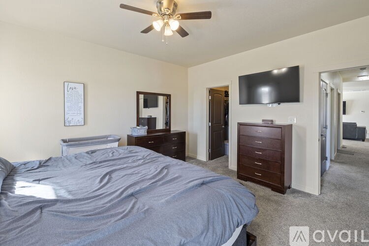 A bedroom with a large bed and a flat screen TV mounted on the wall.
