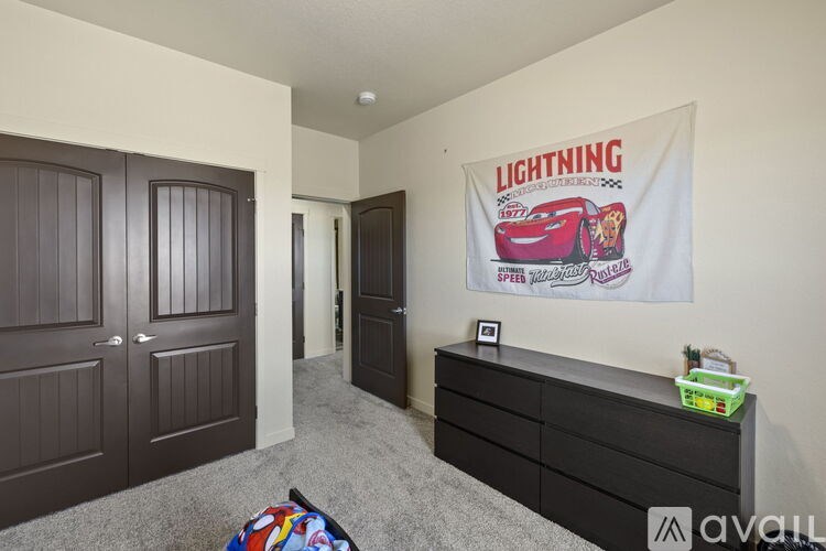 A bedroom with a poster of a red car and the word "Lightning" on the wall.
