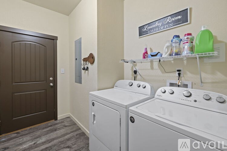 A laundry room with a shelf and two washing machines.