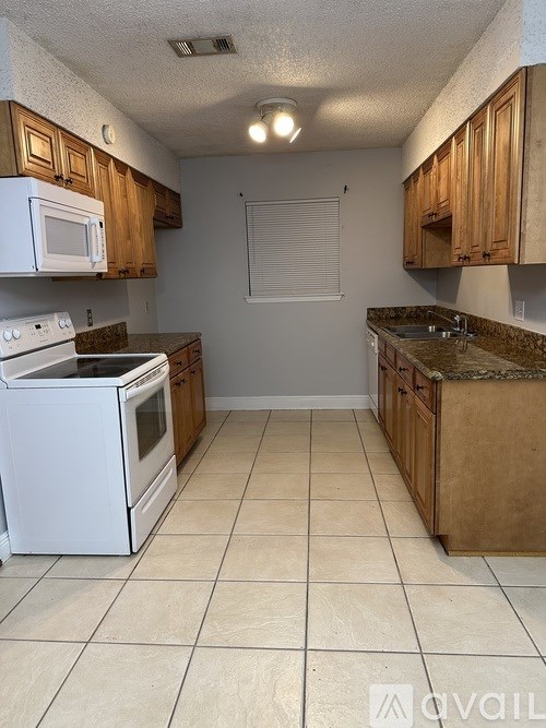 A kitchen with white appliances and wooden cabinets.