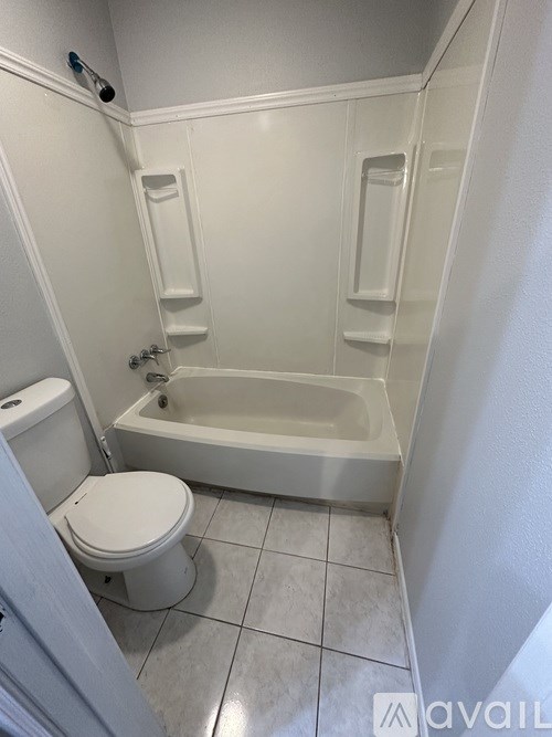 A white toilet sits next to a bathtub in a bathroom.
