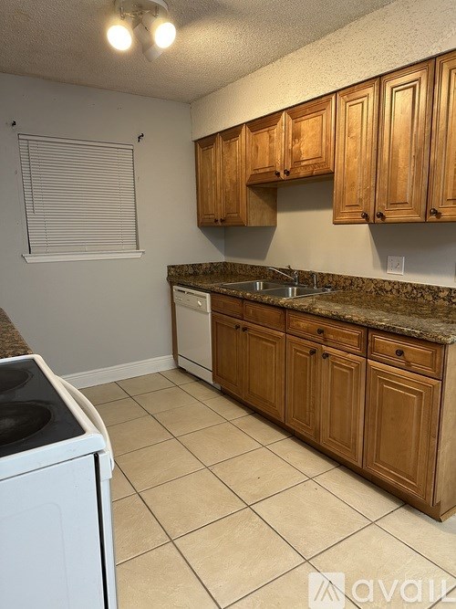 A kitchen with wooden cabinets and a white dishwasher.