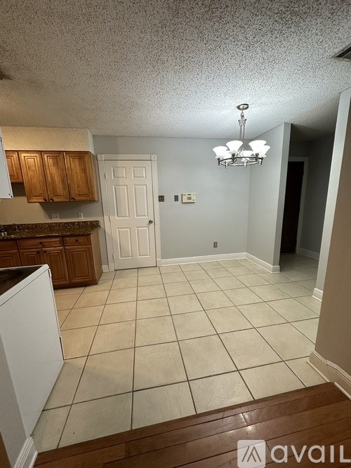 A kitchen with white appliances and wooden cabinets.