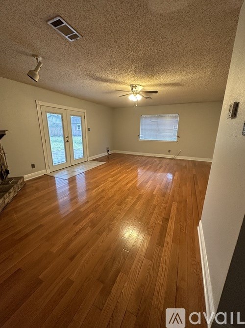 A room with wooden floors and a ceiling fan.