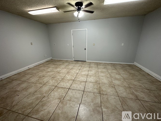Empty room with tile flooring and a ceiling fan.